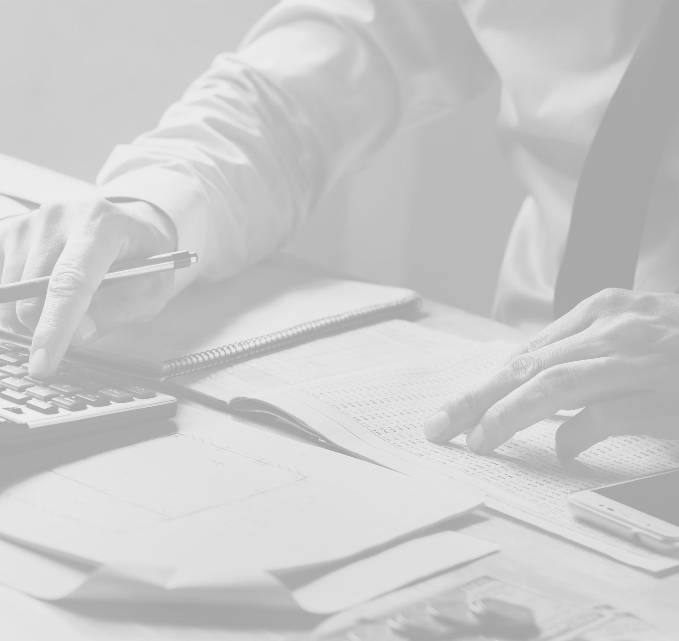 Zwei Hände die am Schreibtisch Rechenarbeiten machen